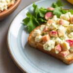 Cottage cheese egg salad served on a slice of toast with fresh greens.